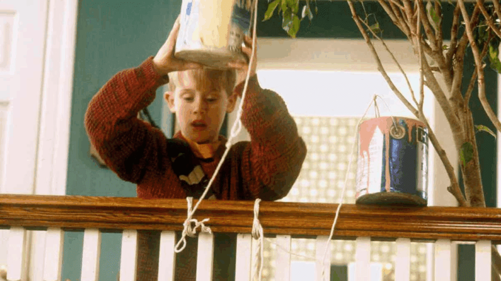 Photo of Kevin from Home Alone as he throws a paint can over the stair railing.